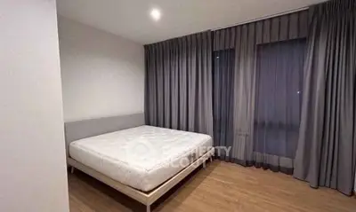 Spacious bedroom with large windows and modern design in a luxury apartment.