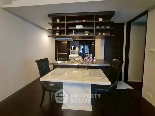 Modern kitchen with sleek marble dining table and dark cabinetry