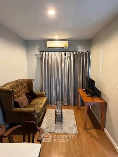 Cozy living room with leather sofa, wooden floor, and modern decor in a stylish apartment.