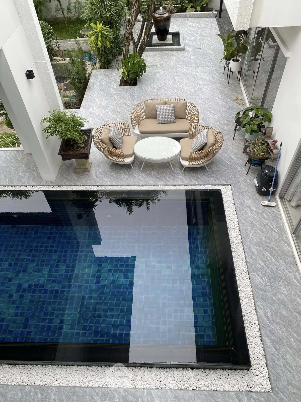 Luxurious modern home with private pool and stylish outdoor seating area, perfect for relaxation and entertainment.