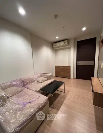Modern living room with cozy sofa and sleek wooden flooring in a stylish apartment.