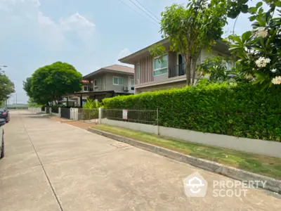 Modern suburban house with lush greenery and spacious driveway in a peaceful neighborhood.