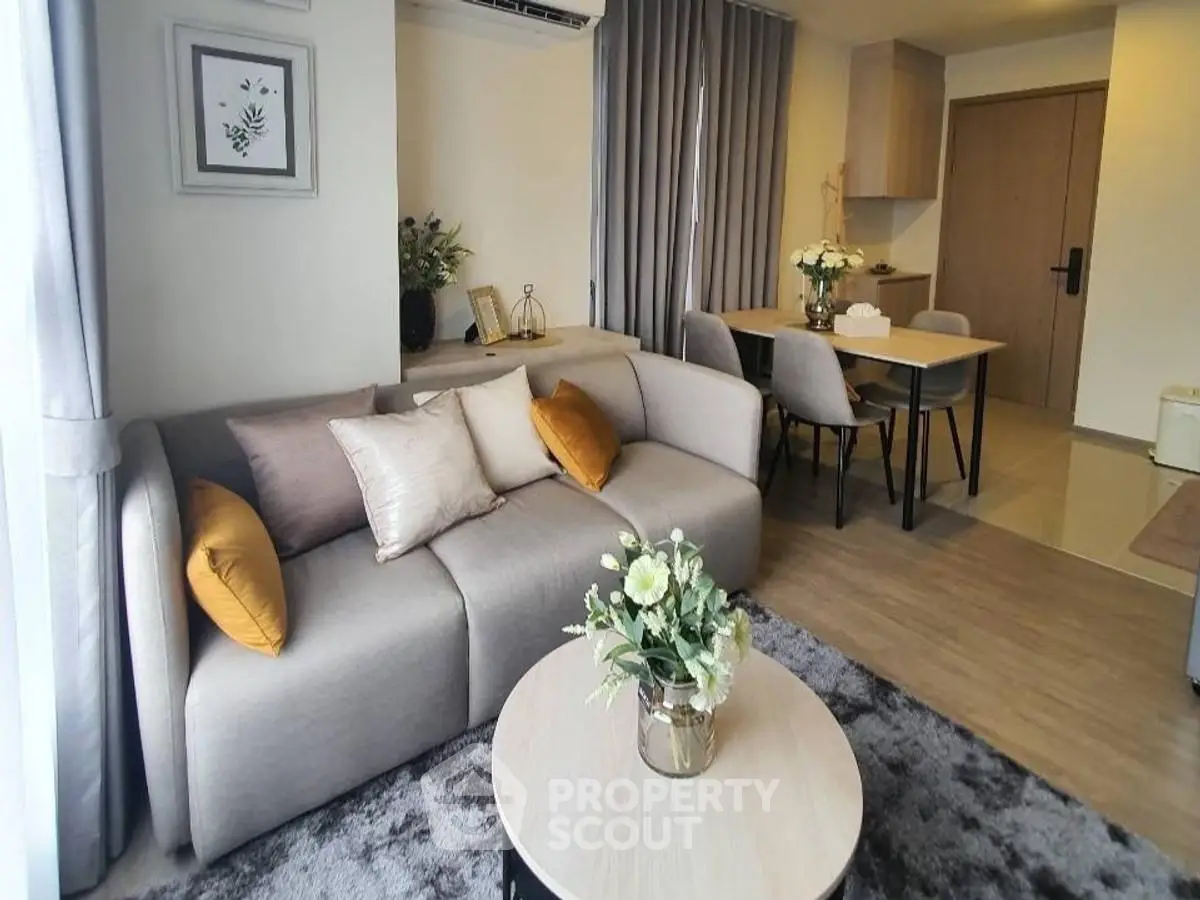 Modern living room with cozy sofa and elegant dining area in open layout apartment.