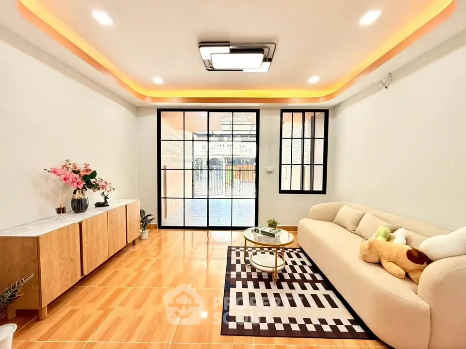 Modern living room with stylish decor and large windows leading to a spacious balcony.