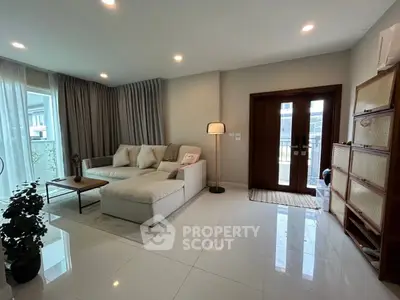 Spacious living room with modern decor and large windows in a stylish home.