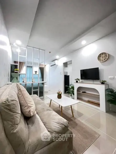 Modern living room with cozy sofa, stylish decor, and wall-mounted TV in a bright apartment.
