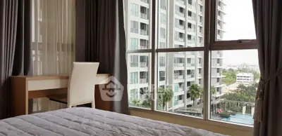 Spacious bedroom with large windows offering stunning city views in a modern high-rise apartment.