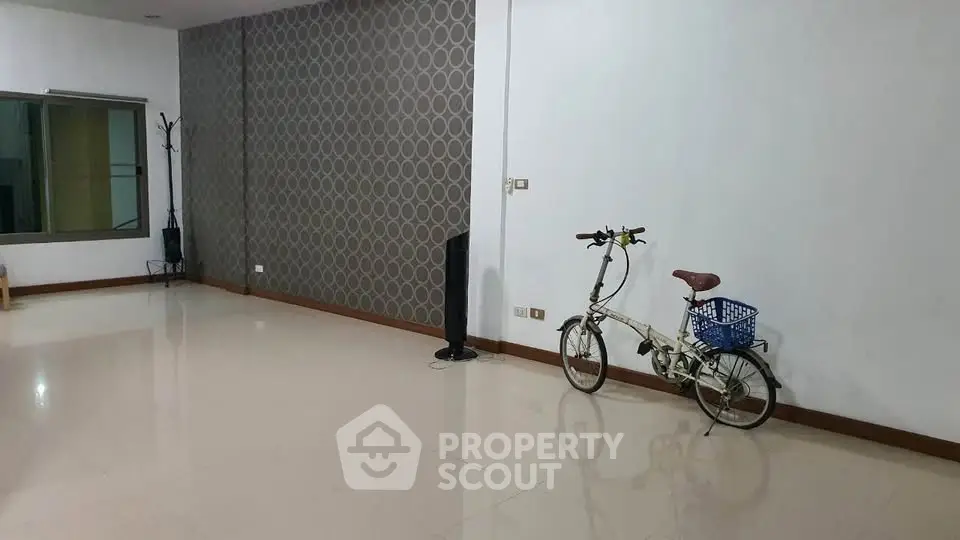 Spacious empty room with modern wallpaper and bicycle, ideal for customization.