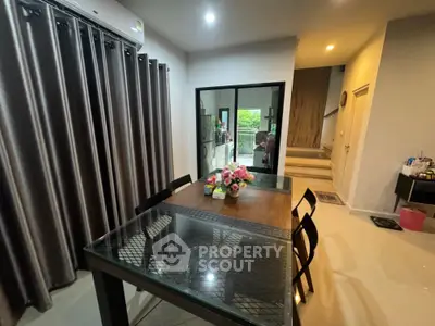 Modern dining area with glass table and elegant curtains in a cozy home setting.