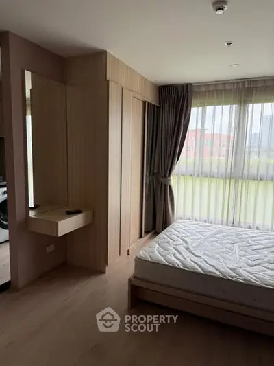 Modern bedroom with large windows and wooden furnishings in a stylish apartment.