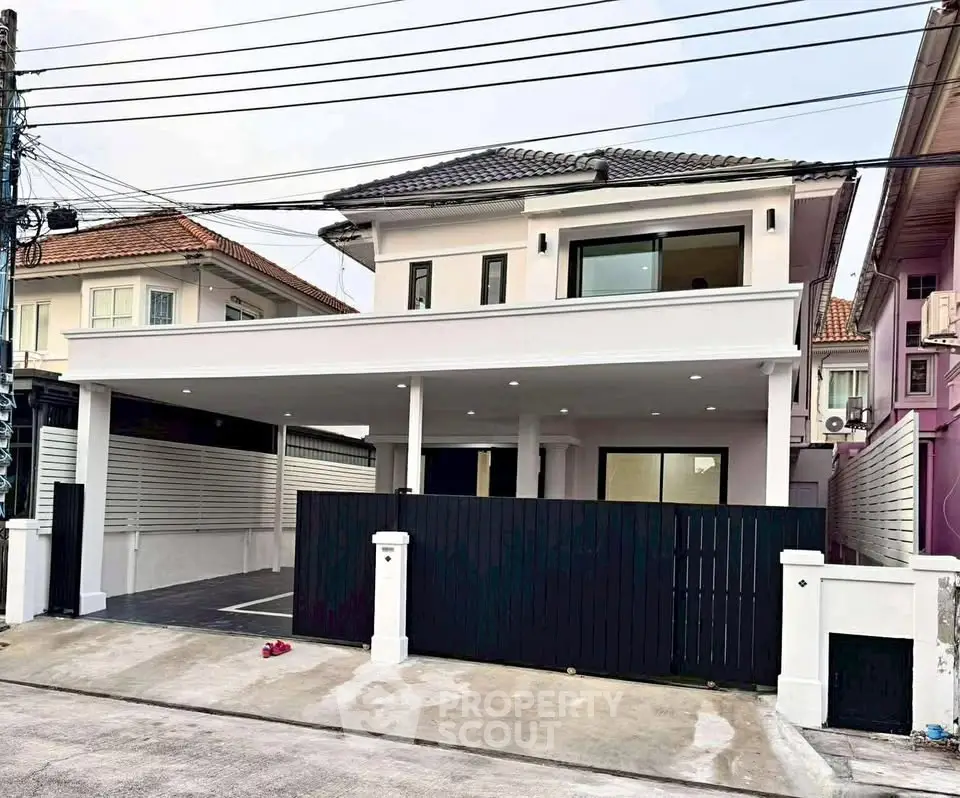 Modern two-story house with spacious driveway and sleek black gate