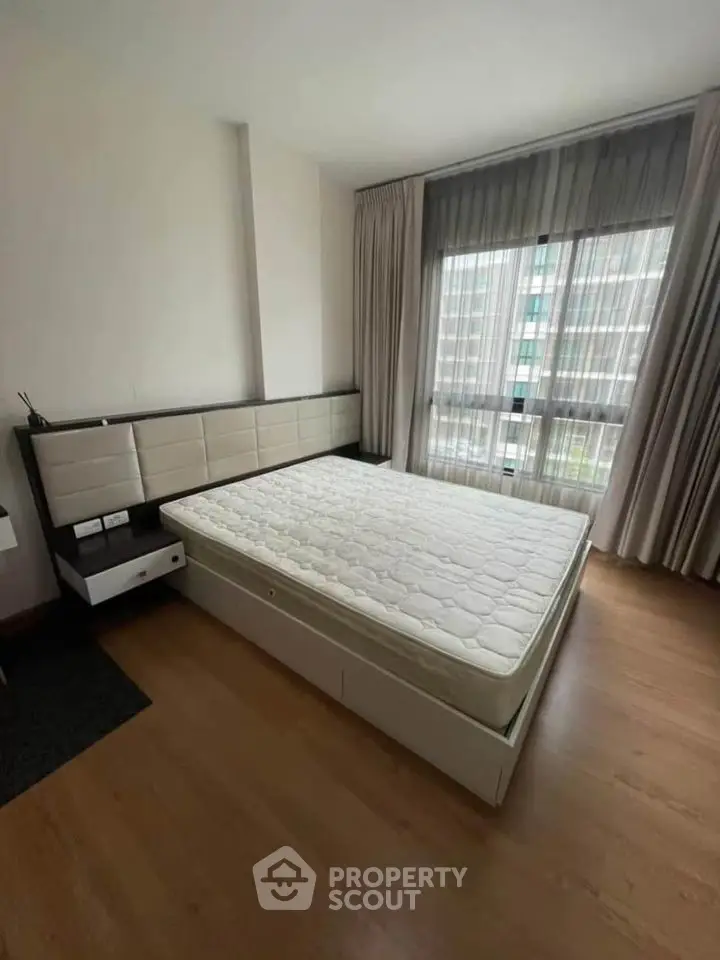 Spacious bedroom with modern decor and large window for natural light