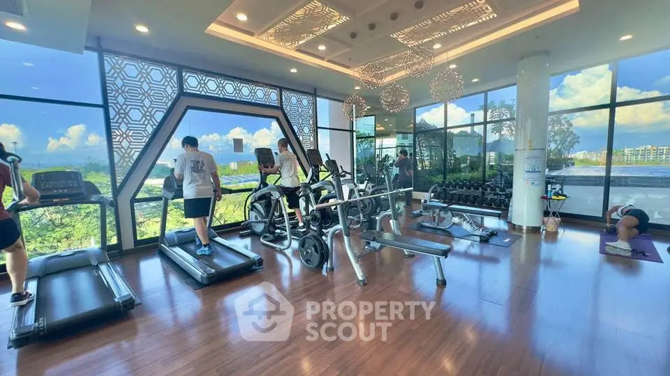 Luxurious gym with panoramic views and modern equipment in upscale residential building.