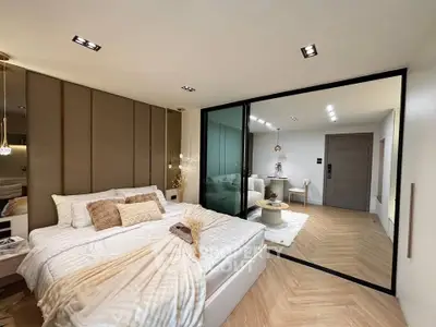 Luxurious modern bedroom with elegant decor and glass partition leading to stylish living area.