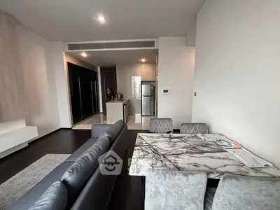 Modern open-plan living room with sleek kitchen and marble dining table