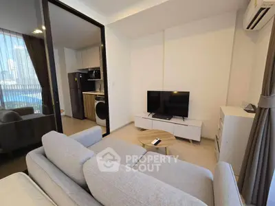 Modern living room with sleek furniture and city view, featuring a cozy sofa and entertainment setup.