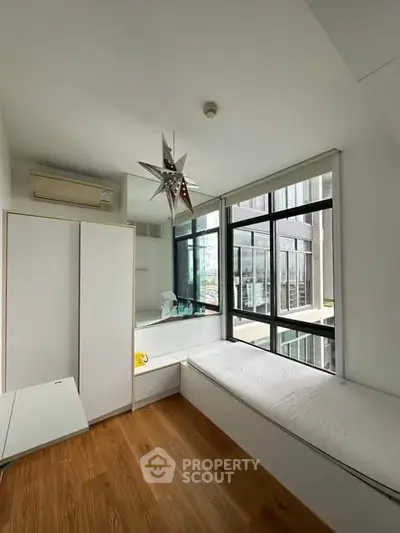 Modern minimalist bedroom with large windows and built-in seating area.
