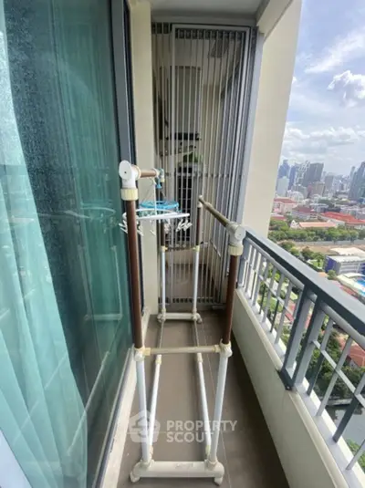 High-rise balcony with city view and drying rack, perfect for urban living.