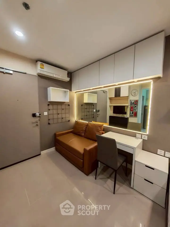 Modern living room with sleek furniture and ambient lighting in a compact apartment.