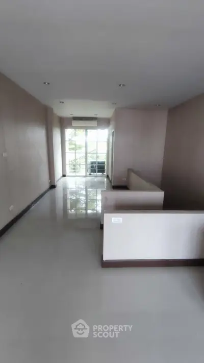 Spacious unfurnished living room with large windows and balcony access.