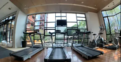 Spacious gym with modern equipment and large windows offering a scenic view.