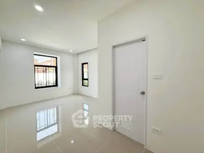 Spacious empty room with glossy tiled floor and large windows, perfect for customization.