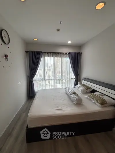 Modern bedroom with city view, stylish decor, and natural light