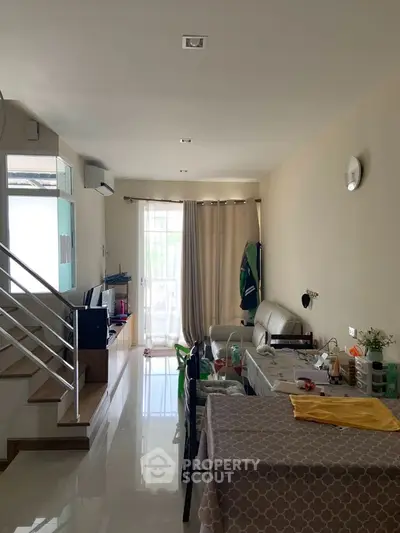 Modern living room with staircase and dining area in bright open layout