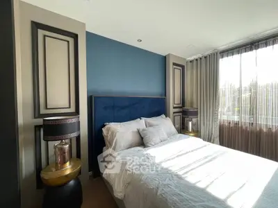 Elegant bedroom with modern decor and large window offering natural light