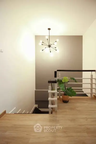 Modern staircase with stylish lighting and wooden flooring in a contemporary home.