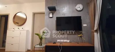 Modern living room with wall-mounted TV, stylish decor, and natural lighting.