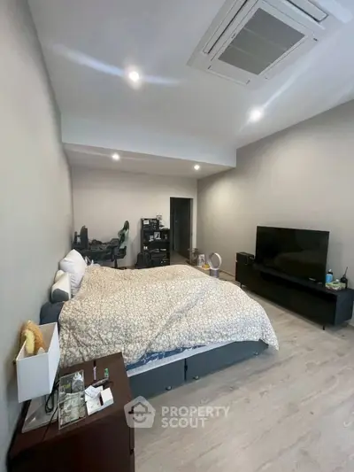 Spacious bedroom with modern decor and entertainment setup