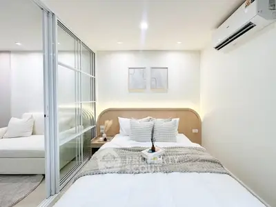 Modern bedroom with cozy decor and sliding glass doors leading to a living area.