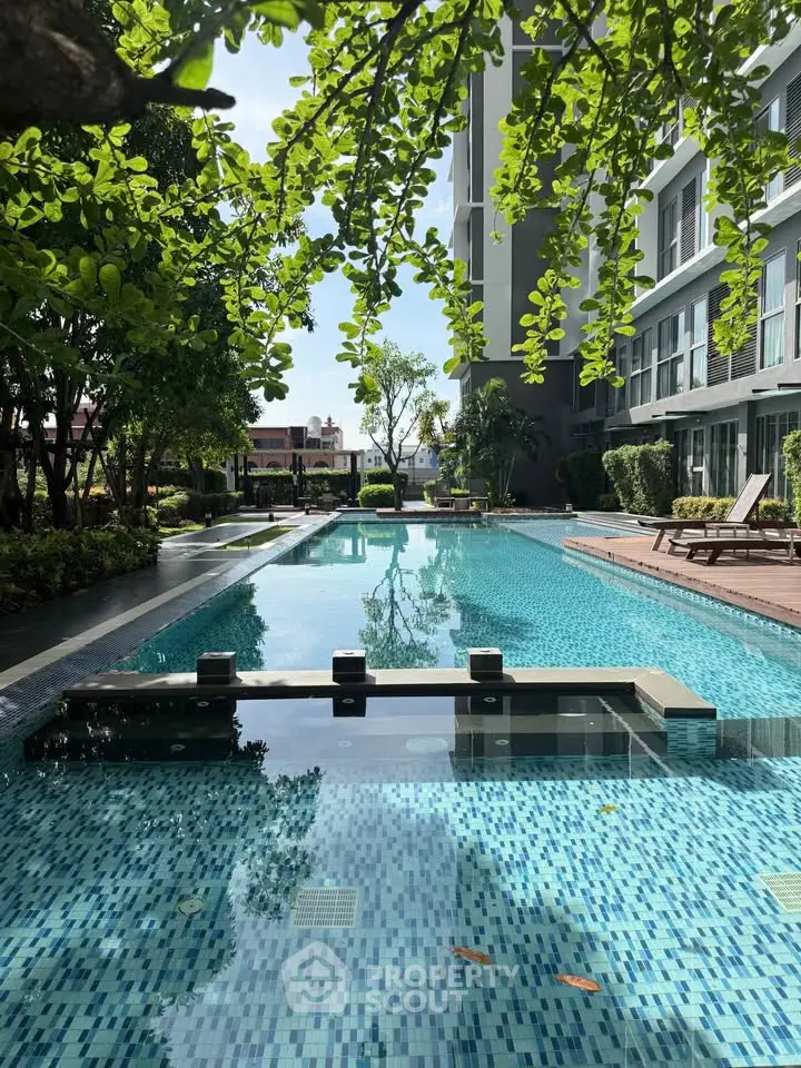 Luxurious condominium pool area with lush greenery and modern design.