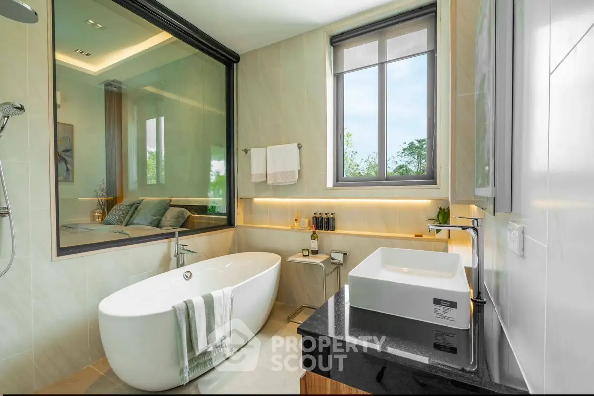 Luxurious bathroom with freestanding bathtub and large window offering serene views.