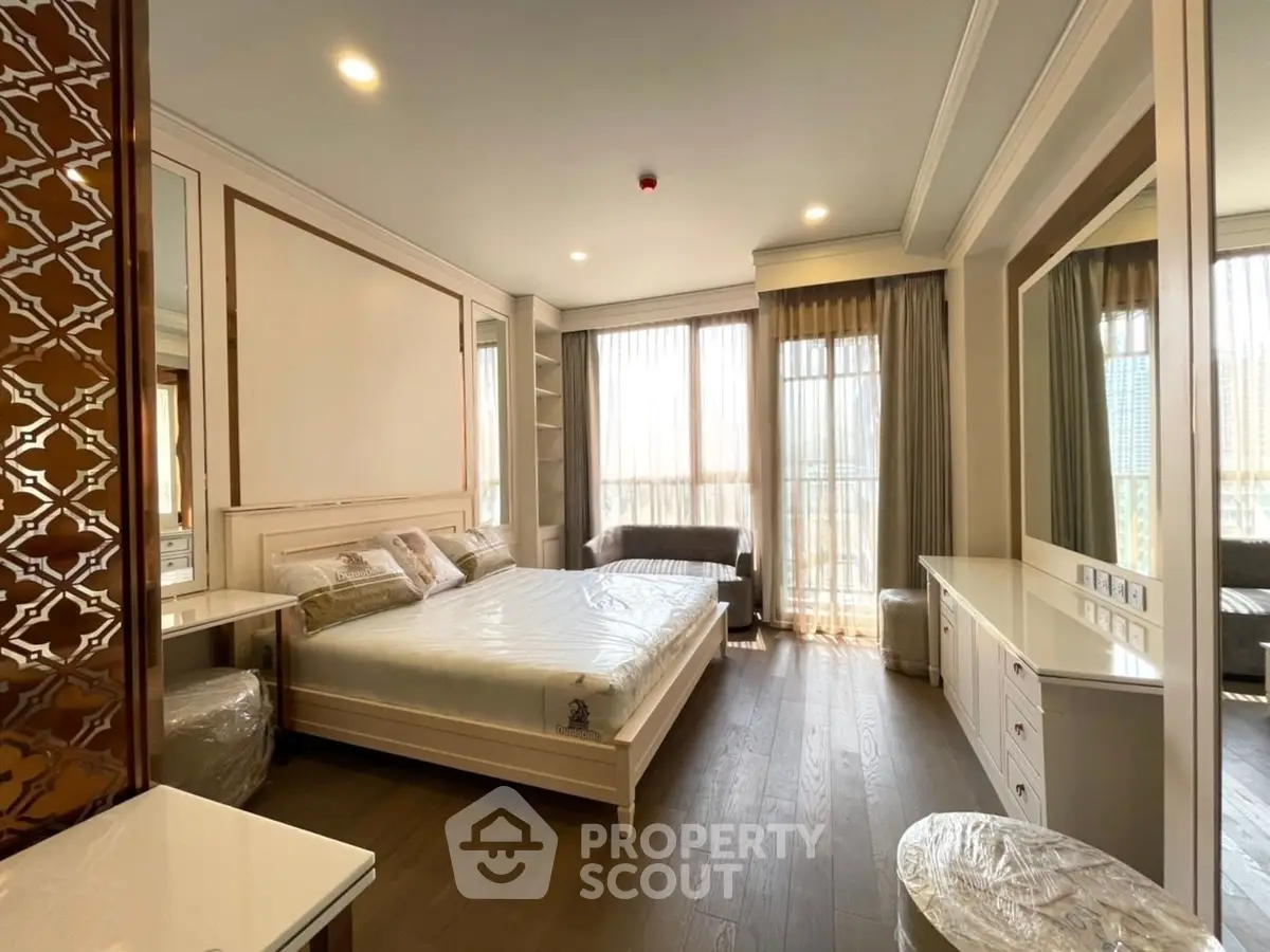 Luxurious bedroom with elegant decor and large windows offering natural light