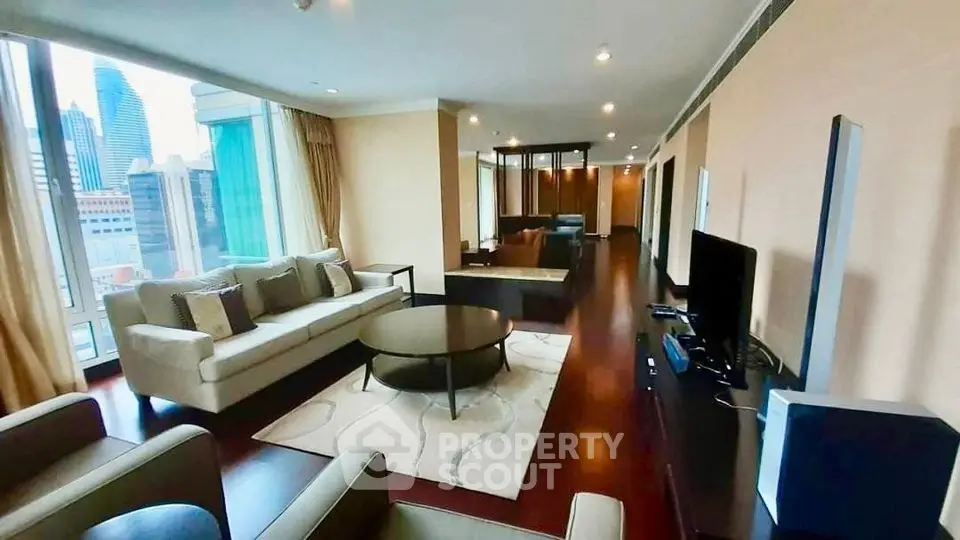 Spacious modern living room with city view, elegant furnishings, and abundant natural light.