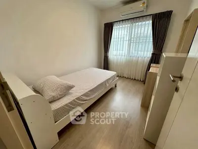 Cozy minimalist bedroom with single bed and air conditioning, perfect for a peaceful retreat.
