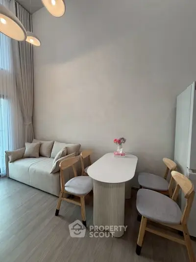 Modern living room with high ceiling, cozy sofa, and elegant dining area in a stylish apartment.
