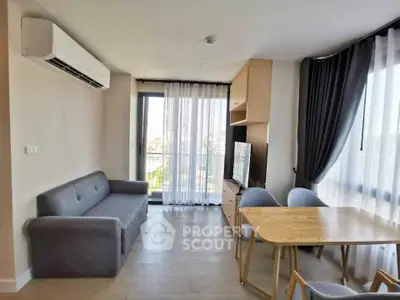 Modern living room with large windows and stylish furniture in a high-rise apartment.