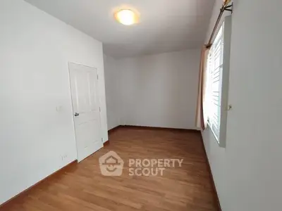 Spacious empty room with wooden flooring and natural light