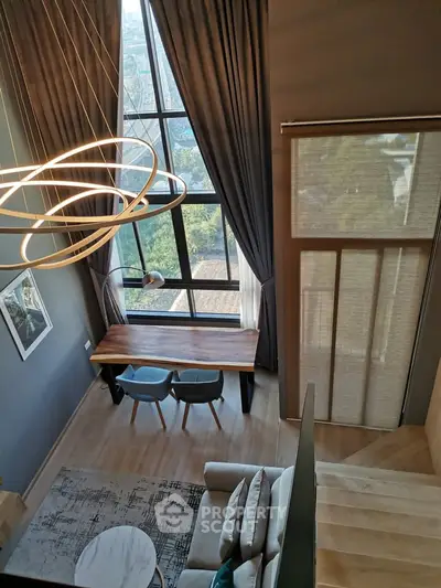 Stunning loft-style living room with floor-to-ceiling windows and modern decor.