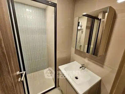 Modern bathroom with sleek shower and stylish vanity in contemporary home.