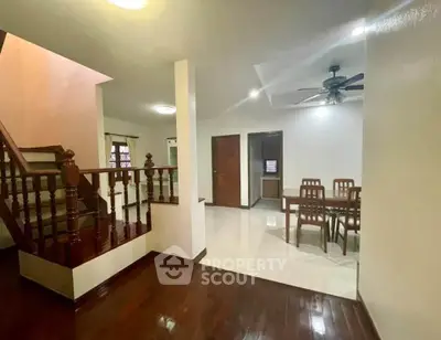 Spacious interior with elegant wooden staircase and dining area, perfect for family gatherings.