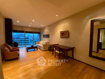 Spacious modern living room with wooden flooring and city view balcony.