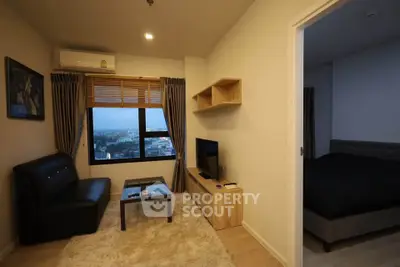 Modern living room with city view, cozy seating, and stylish decor in a high-rise apartment.