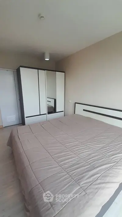 Spacious bedroom with modern wardrobe and cozy bedding in a stylish apartment.