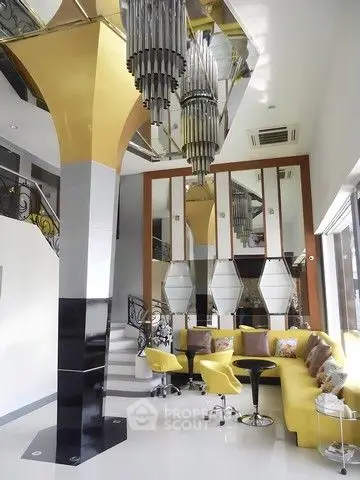 Luxurious modern living room with unique chandelier and vibrant yellow seating