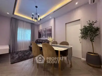 Elegant dining area with modern chandelier and cozy seating in a stylish apartment.
