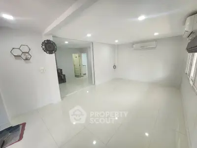 Spacious modern living room with sleek white tiles and air conditioning, perfect for comfortable living.